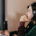 A call center agent wearing a headset is focused on improving customer engagement through the use of relationship mapping tools