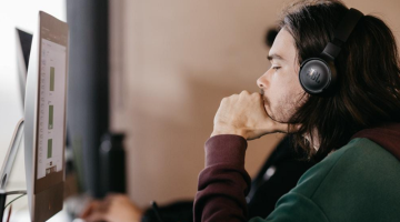 A call center agent wearing a headset is focused on improving customer engagement through the use of relationship mapping tools