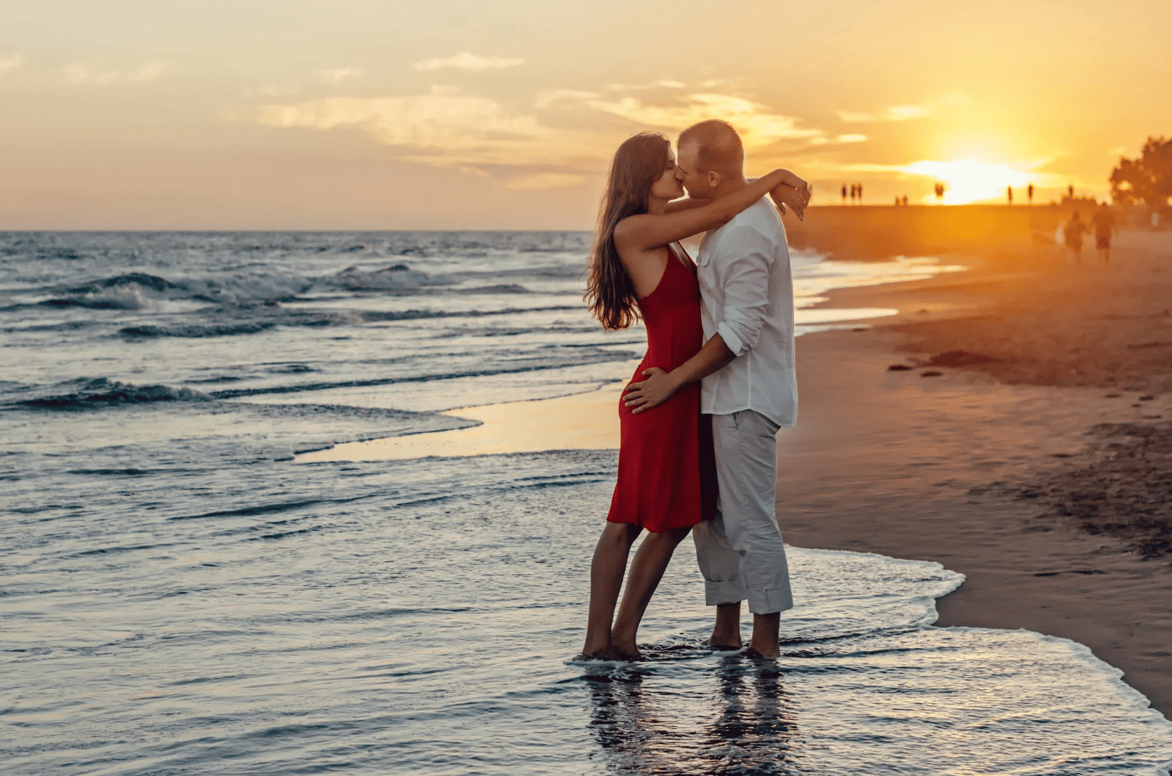 couple-kissing-on-beach-during-golden-hour